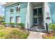 Exterior of building with teal paint, an exterior staircase, a wreath, and lush greenery and landscaping at 11404 2Nd N St # 3, St Petersburg, FL 33701