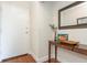Hallway featuring hardwood floors, wall decorations, a white door and a table with a mirror and small decorations at 11404 2Nd N St # 3, St Petersburg, FL 33701
