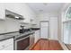 Compact kitchen features modern appliances, white cabinets, and a sleek black countertop, enhanced by natural light at 11404 2Nd N St # 3, St Petersburg, FL 33701