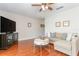 Living room with wood floors, a comfortable sofa, a ceiling fan, and decorative art at 11404 2Nd N St # 3, St Petersburg, FL 33701