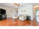 Living room with wood floors, a sectional sofa, a ceiling fan, and decorative art at 11404 2Nd N St # 3, St Petersburg, FL 33701