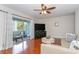 Bright living room featuring a ceiling fan, an entertainment center, sliding glass doors to an outdoor balcony and hardwood floors at 11404 2Nd N St # 3, St Petersburg, FL 33701