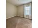 Bright carpeted bedroom features a window with natural lighting at 11489 Bitola Dr, Odessa, FL 33556