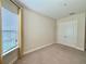 Neutral carpeted bedroom with double door closet and a large window at 11489 Bitola Dr, Odessa, FL 33556