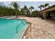 Community pool with plenty of patio furniture and palm trees for shade at 11489 Bitola Dr, Odessa, FL 33556