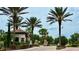 Community entrance with brick-paved road and tropical palm trees at 11489 Bitola Dr, Odessa, FL 33556