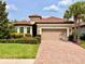 Charming home boasts a red tile roof, manicured lawn, and inviting two-car garage at 11489 Bitola Dr, Odessa, FL 33556