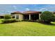 Home exterior with well-maintained lawn, landscaping, and screened patio at 11489 Bitola Dr, Odessa, FL 33556