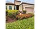 Well-maintained home with a beautiful garden featuring lush landscaping and colorful flowering bushes at 11489 Bitola Dr, Odessa, FL 33556