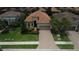 Inviting home exterior with a paver driveway, lush landscaping, and a well-maintained lawn at 11489 Bitola Dr, Odessa, FL 33556