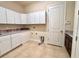 Well-lit laundry room features white cabinets, granite countertop, and tile flooring at 11489 Bitola Dr, Odessa, FL 33556