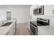 This kitchen has stainless steel appliances and bright white stone countertops for a modern look at 116 Leisure Pl, Rotonda West, FL 33947