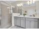 Modern bathroom with double sinks, a glass-enclosed shower, and contemporary fixtures at 11626 Blue Woods Dr, Riverview, FL 33569