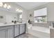 Luxurious bathroom featuring a soaking tub, double vanity, and elegant finishes at 11626 Blue Woods Dr, Riverview, FL 33569