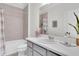 Bathroom with shower-tub combo, gray vanity, and neutral-colored tile at 11626 Blue Woods Dr, Riverview, FL 33569