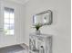 Inviting entryway featuring a stylish table, decorative mirror, and tiled flooring at 11626 Blue Woods Dr, Riverview, FL 33569