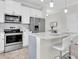 Contemporary kitchen boasts stainless steel appliances, white cabinets, and an island with barstool seating at 11626 Blue Woods Dr, Riverview, FL 33569