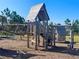 Community playground with a wooden play structure, rope bridge, and climbing features at 11626 Blue Woods Dr, Riverview, FL 33569