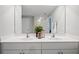Bathroom showcasing a double sink vanity with a large mirror and neutral wall color at 118 Leisure Pl, Rotonda West, FL 33947