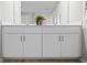Bathroom vanity with double sinks, white cabinetry, and bronze hardware at 119 Leisure Pl, Rotonda West, FL 33947