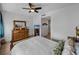 Bright bedroom featuring a decorative mirror, dresser, ceiling fan, and a glimpse into an open hallway at 1208 E Kennedy Blvd # 914, Tampa, FL 33602