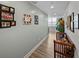 Hallway with hardwood floors, gray walls adorned with photos, and a view of a window with natural light at 1208 E Kennedy Blvd # 914, Tampa, FL 33602