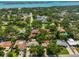 Expansive aerial view of a neighborhood showcasing lush trees and a waterfront view in the distance at 1500 Robinson N Dr, St Petersburg, FL 33710