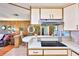 Open kitchen with cooktop island and a view into the living area, featuring wood paneling and a cozy atmosphere at 1500 Robinson N Dr, St Petersburg, FL 33710