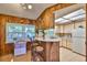 Kitchen with a breakfast bar, wood paneling, white cabinetry, and a view out the window at 1500 Robinson N Dr, St Petersburg, FL 33710