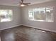 Bright bedroom with hardwood floors, two windows and a ceiling fan offering a comfortable living space at 162 Sw Lincoln N Cir, St Petersburg, FL 33703