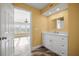Bathroom featuring a white vanity with marble countertop and neutral yellow walls at 1768 Lago Vista Blvd, Palm Harbor, FL 34685