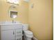Traditional bathroom design features a white vanity with a speckled countertop and round mirror at 1768 Lago Vista Blvd, Palm Harbor, FL 34685