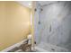 Modern bathroom with a tiled walk-in shower, marble walls and stone floor at 1768 Lago Vista Blvd, Palm Harbor, FL 34685