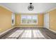 A sunny bedroom boasting wood floors, natural light, a ceiling fan, and neutral paint at 1768 Lago Vista Blvd, Palm Harbor, FL 34685