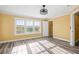 Well-lit bedroom showcasing a large window, wood floors, a ceiling fan, and a walk-in closet at 1768 Lago Vista Blvd, Palm Harbor, FL 34685