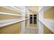 Walk-in closet with custom shelving and rods for optimal storage at 1768 Lago Vista Blvd, Palm Harbor, FL 34685