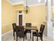 Dining room featuring a modern chandelier, stylish table set, wainscoting, and a glimpse of the wine cellar at 1768 Lago Vista Blvd, Palm Harbor, FL 34685