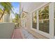 Exterior side view of the home featuring white trim, a brick walkway, and palm trees providing shade and character at 1768 Lago Vista Blvd, Palm Harbor, FL 34685