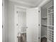 Bright hallway features a glimpse into the bathroom and walk-in closet with custom shelving at 1768 Lago Vista Blvd, Palm Harbor, FL 34685