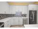 Well-lit kitchen featuring stainless steel appliances, tiled backsplash, wood floors, and light countertops at 1768 Lago Vista Blvd, Palm Harbor, FL 34685