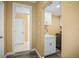 Functional laundry room with white cabinets, a utility sink, and modern washer and dryer at 1768 Lago Vista Blvd, Palm Harbor, FL 34685