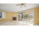 Bright living room with fireplace, ceiling fan, and sliding glass doors to screened porch at 1768 Lago Vista Blvd, Palm Harbor, FL 34685