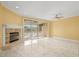 Inviting living room with a cozy fireplace, neutral tile flooring, and sliding doors to outdoor space at 1768 Lago Vista Blvd, Palm Harbor, FL 34685