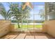 Inviting screened-in patio with brick floors, a ceiling fan, and scenic views of the adjacent water at 1768 Lago Vista Blvd, Palm Harbor, FL 34685