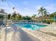 Community pool surrounded by lounge chairs and palm trees, perfect for relaxation and leisure at 1768 Lago Vista Blvd, Palm Harbor, FL 34685