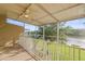 Screened in porch overlooking lush backyard with mature trees and water views at 1768 Lago Vista Blvd, Palm Harbor, FL 34685