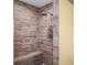 Modern shower with wood-look tile, rainfall shower head, and built-in bench at 1768 Lago Vista Blvd, Palm Harbor, FL 34685