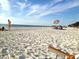 Idyllic beach scene with sunbathers, clear sky, and a sandy shore perfect for a relaxing day by the water at 1829 1St E Ave, Bradenton, FL 34208