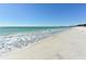 Expansive view of a serene white sand beach with gentle waves and clear blue sky, ideal for relaxation at 1829 1St E Ave, Bradenton, FL 34208