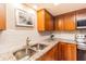 Kitchen with granite countertops, stainless steel sink, tile backsplash and wooden cabinets at 1829 1St E Ave, Bradenton, FL 34208